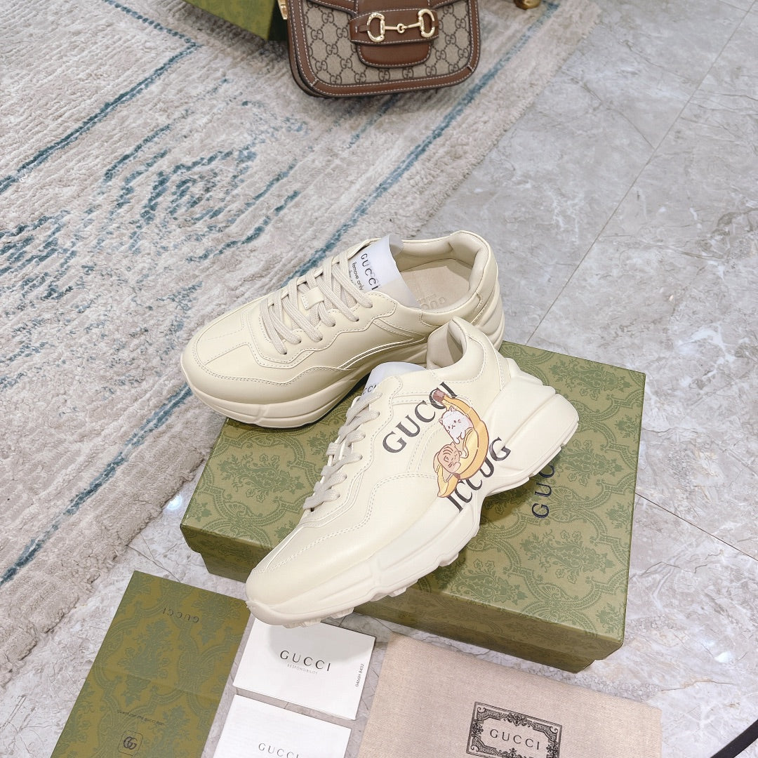 Gucci unisex sneakers, white with visible laces and logo graphic on the side