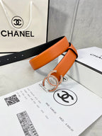 Orange leather belt with gold jeweled CC buckle, strap loop and punched holes