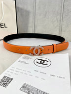 Orange leather belt with gold jeweled CC buckle, punched holes and black lining