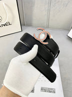 Chanel belt on white glove: black textured strap with gold-tone CC buckle