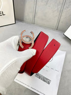 Red leather belt with large gold-tone Chanel CC buckle and matching pin holes.