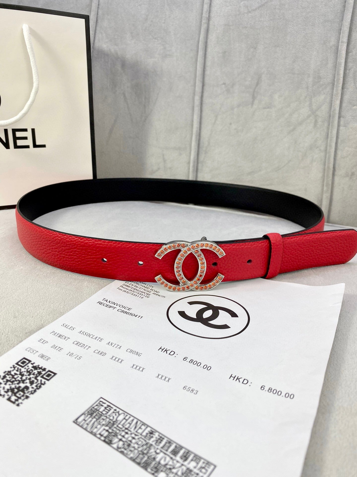Red leather belt with gold-tone Chanel CC buckle and adjustable holes, black underside.