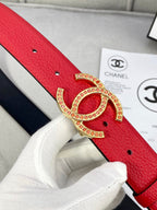 Red leather belt close-up with gold-tone Chanel CC buckle and black underside.