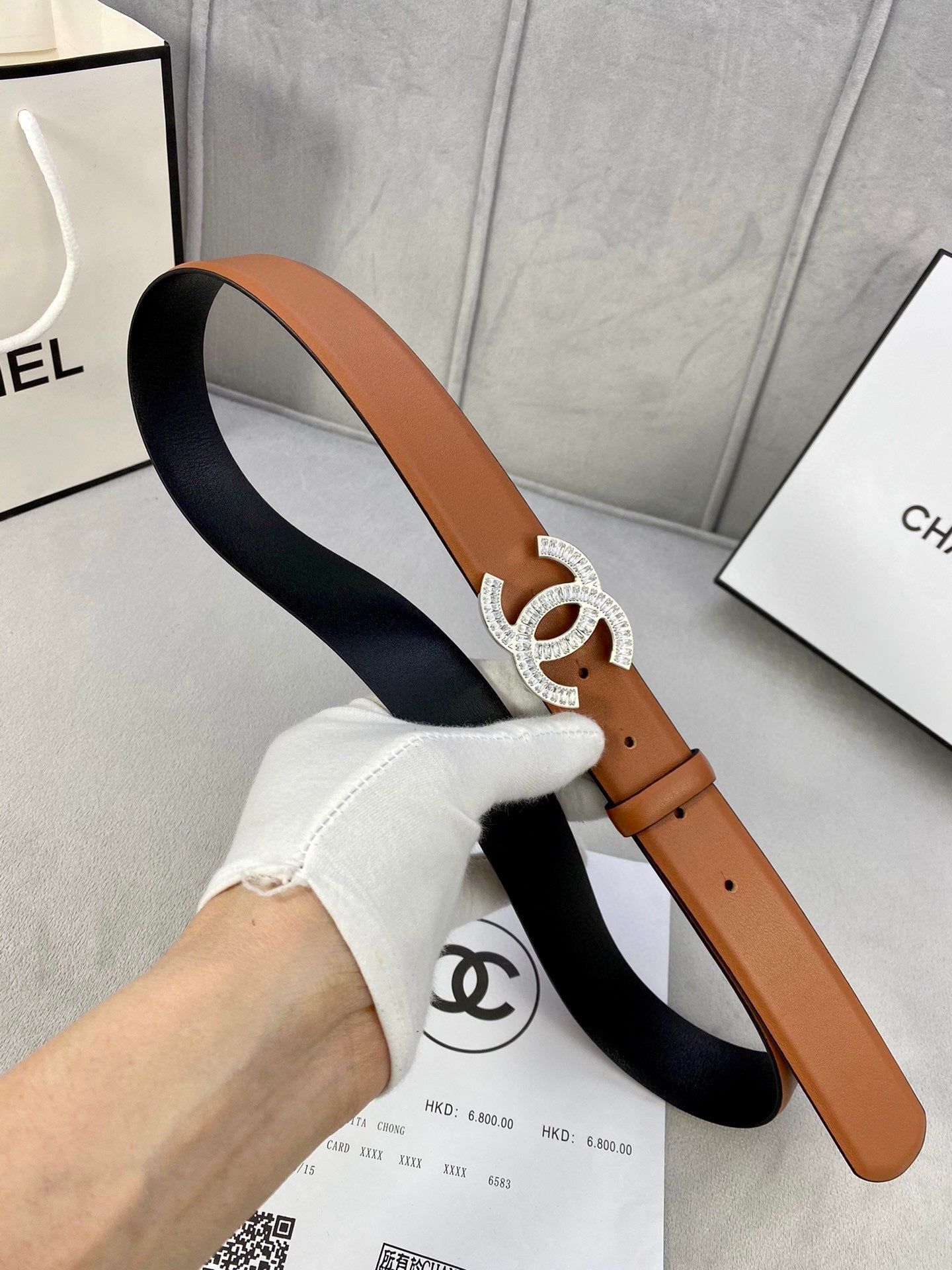 Tan and black belt with rhinestone CC buckle and leather strap holes