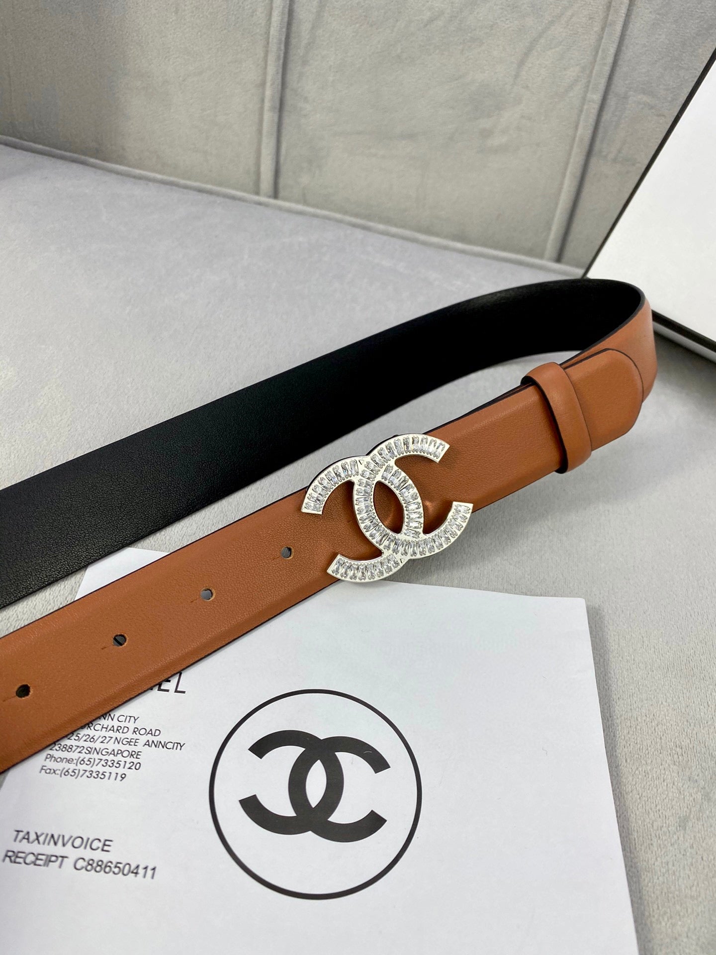 Tan leather belt with rhinestone CC buckle on black belt side