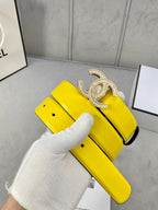 Yellow leather belt with silver rhinestone CC buckle on bright yellow strap