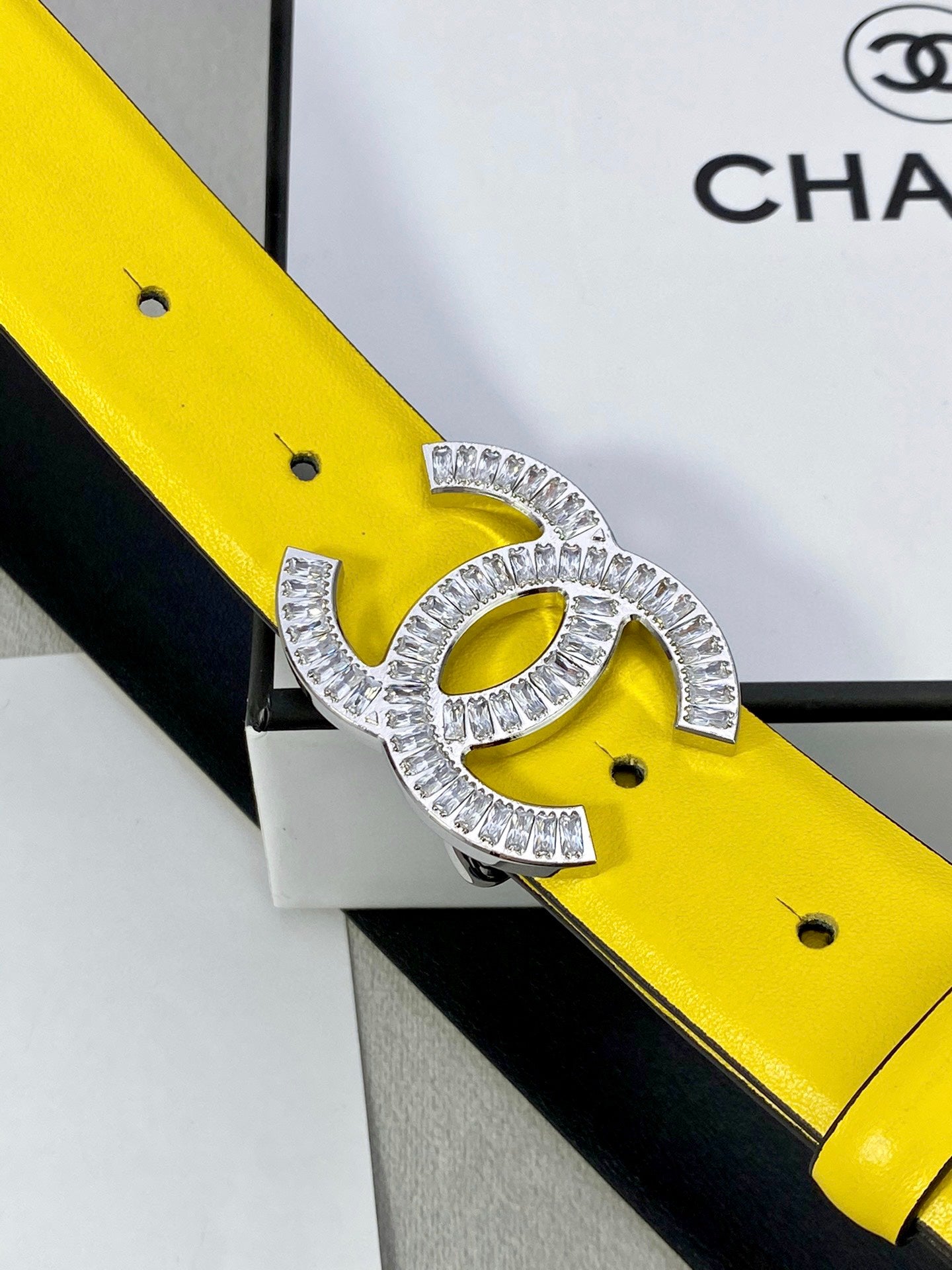 Close-up of yellow leather belt with silver rhinestone Chanel CC buckle
