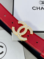 Close-up of red leather belt with Chanel gold-tone double C buckle ornament