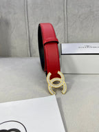 Red leather belt side view with Chanel gold-tone double C buckle on box