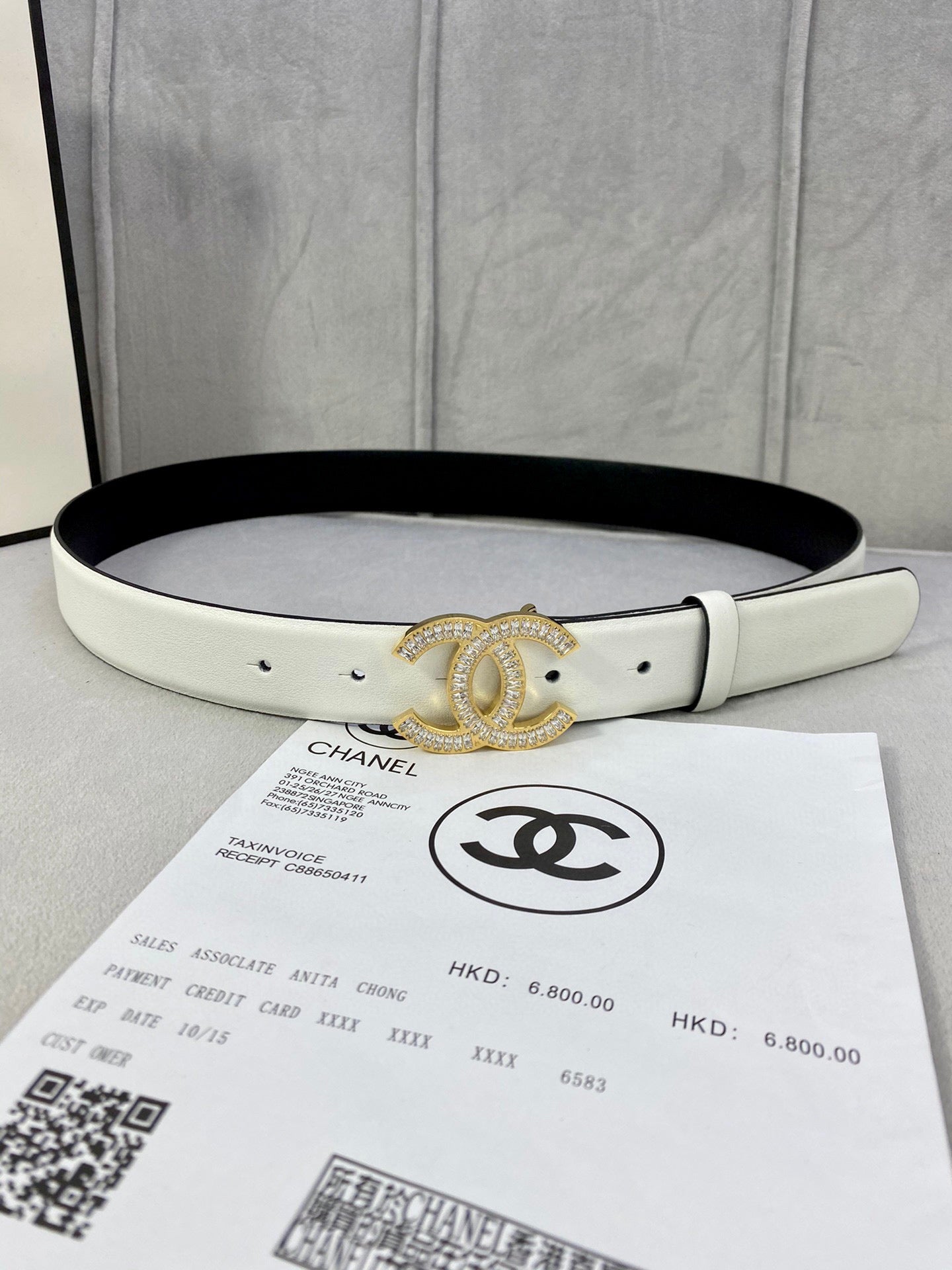 White leather belt with gold-tone CC logo buckle and small grommet holes