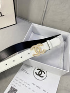 White leather belt with gold-tone CC logo buckle laid in a gift box