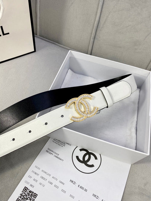 White leather belt with gold-tone CC logo buckle laid in a gift box