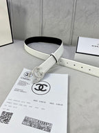 White leather belt with rhinestone CC logo buckle laid flat beside packaging