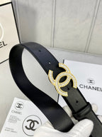 Black leather belt with rhinestone CC buckle on the strap, angled view
