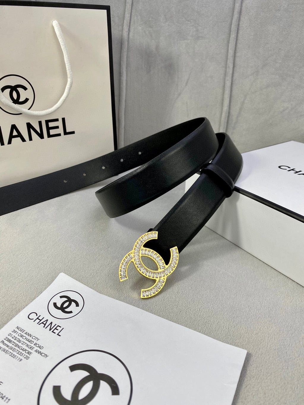 Black leather belt with rhinestone CC buckle centered on the strap