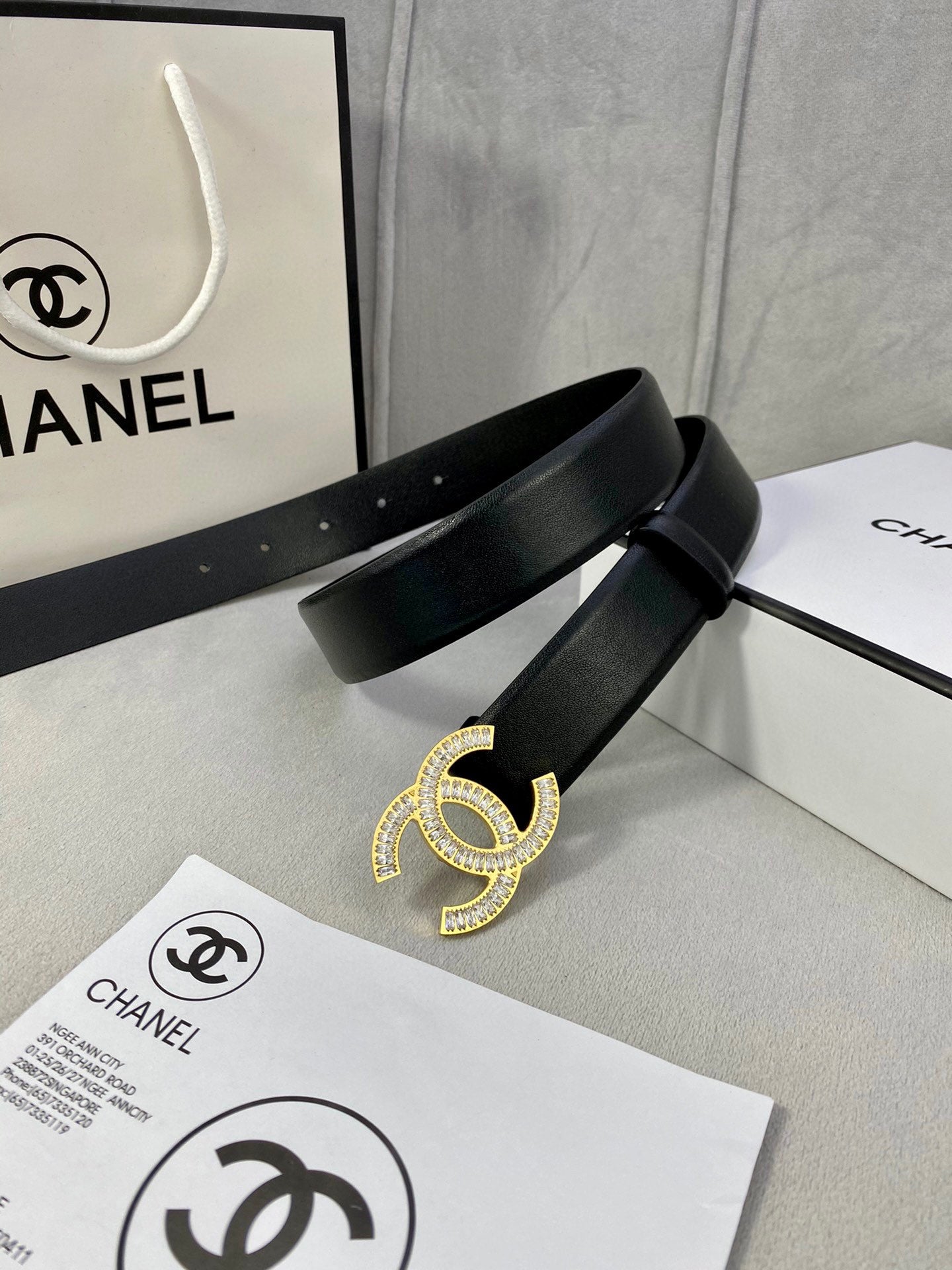Black leather belt with rhinestone CC buckle centered on the strap