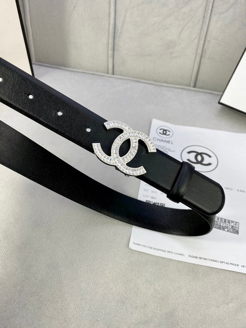 Black leather belt featuring a rhinestone CC emblem buckle and adjustable holes