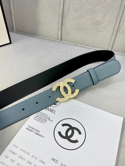 Light blue Chanel belt on a flat surface with gold CC buckle detail.