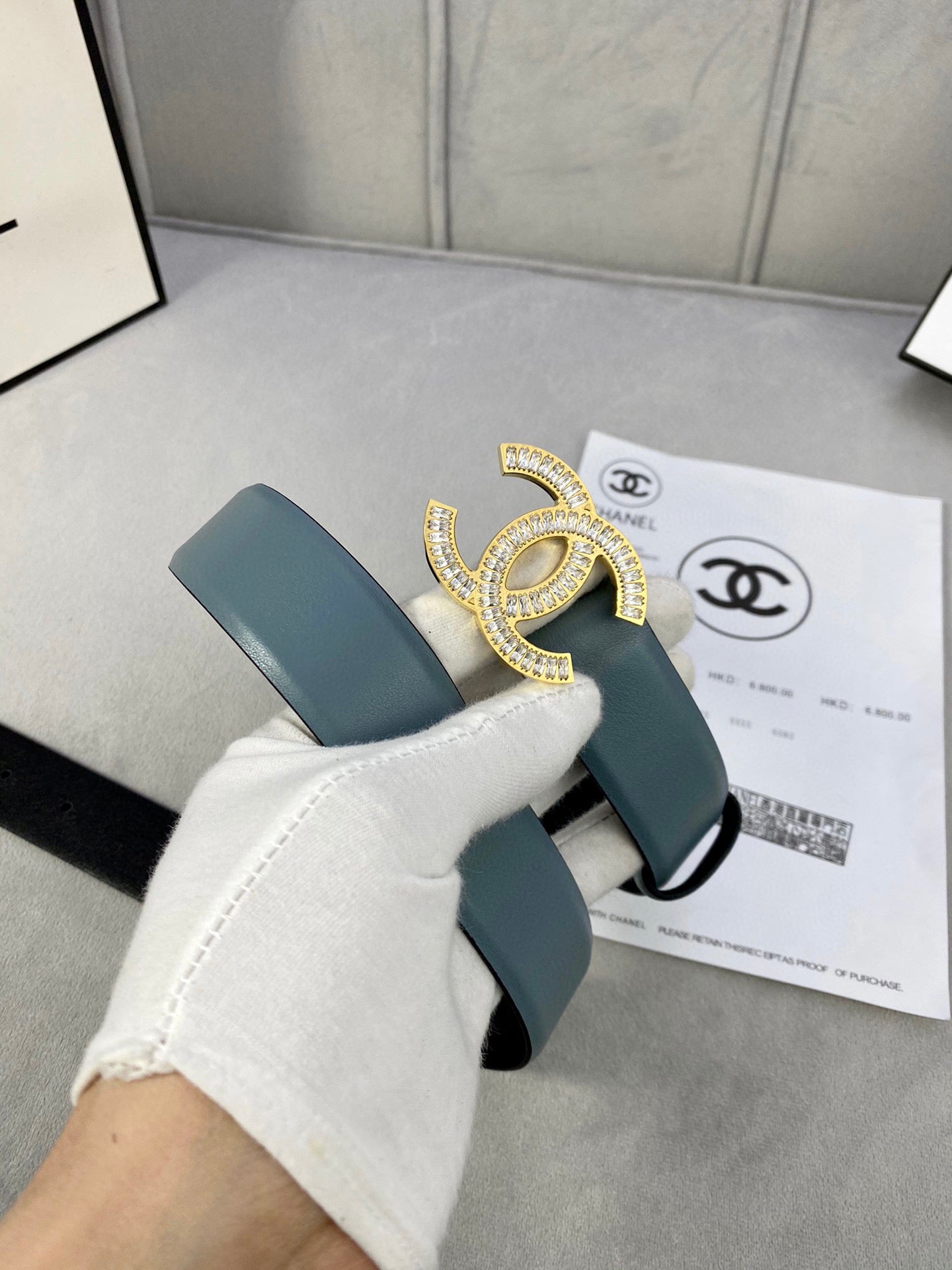 Light blue Chanel belt with gold-toned CC buckle and visible leather edge.