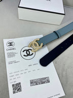 Light blue Chanel belt laid across documents with gold-toned CC buckle.