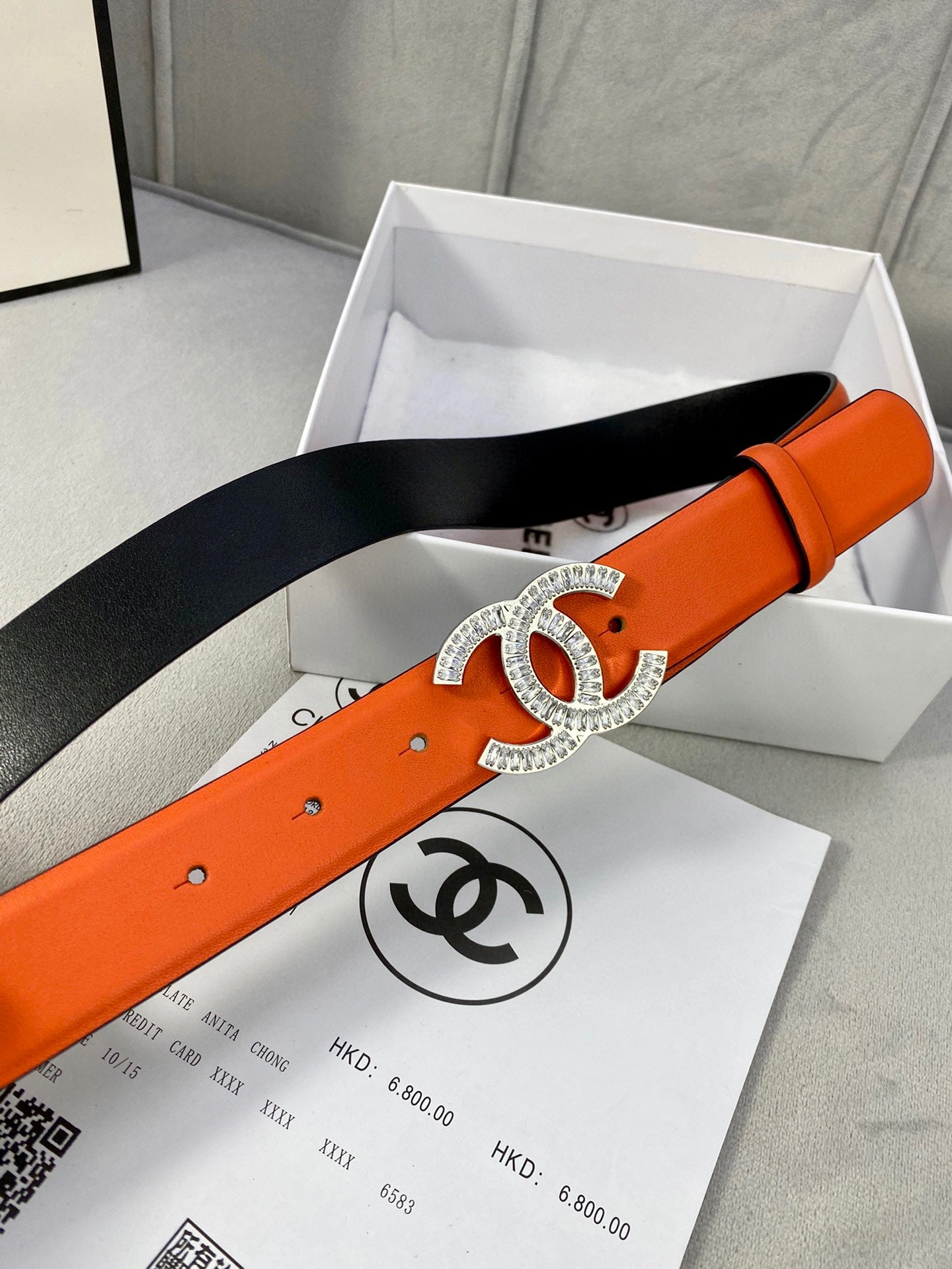 Chanel orange belt with crystal CC buckle on black backing