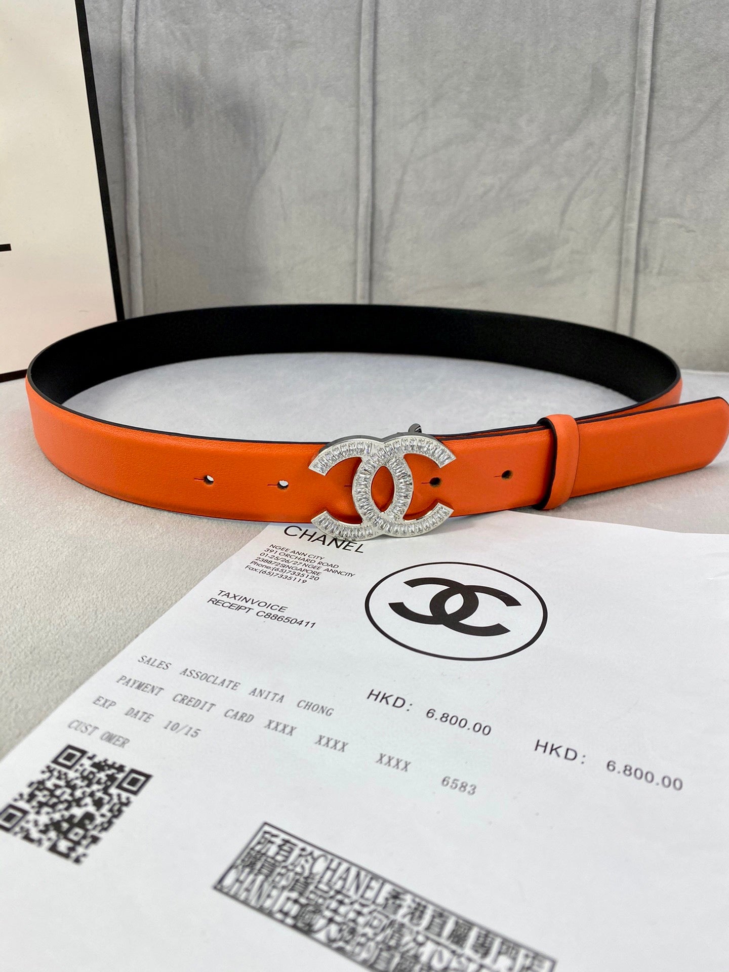 Chanel orange belt with black underside and crystal CC buckle, adjustable holes