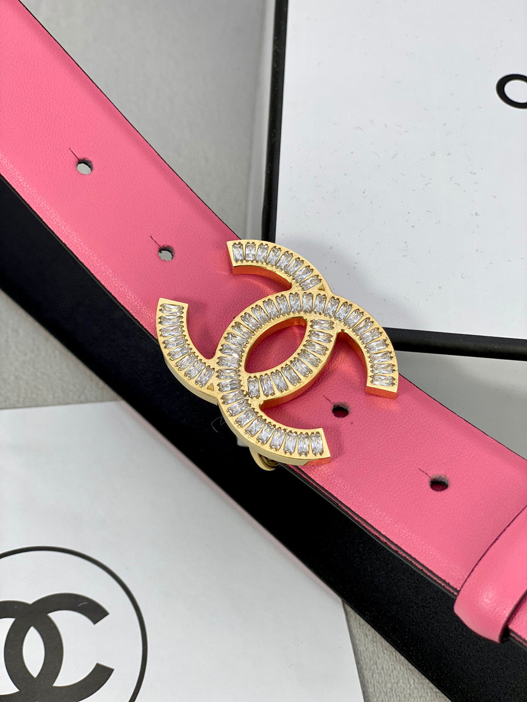 Chanel belt detail: pink strap with black lining and rhinestone CC buckle