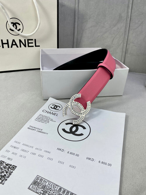 Chanel belt featuring a pink strap, black underside, and sparkling CC buckle