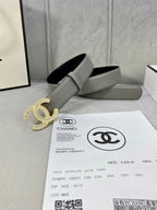 Chanel belt with light gray leather strap and gold-tone CC buckle, flat lay