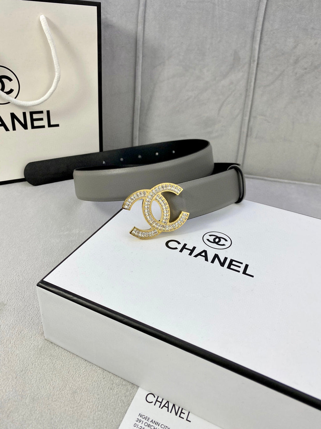 Chanel belt in light gray leather with gold-tone CC buckle, on the box