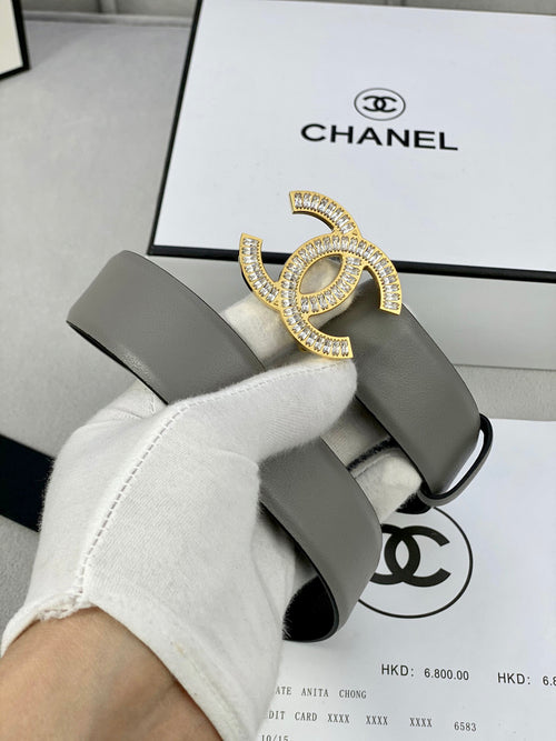 Chanel belt with light gray strap and gold-tone CC buckle, shown close-up