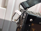 Monogram canvas crossbody strap with silver hardware and black leather keeper.