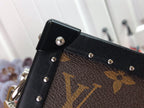 Louis Vuitton bag corner detail with black leather flap, rivets, and monogram canvas