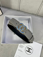 Grey leather belt with blue-and-gold CC buckle, shown from side angle