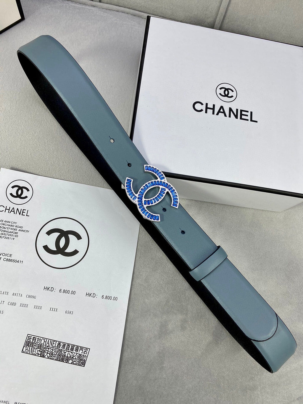 Chanel belt with light blue strap and CC logo buckle, shown with packaging