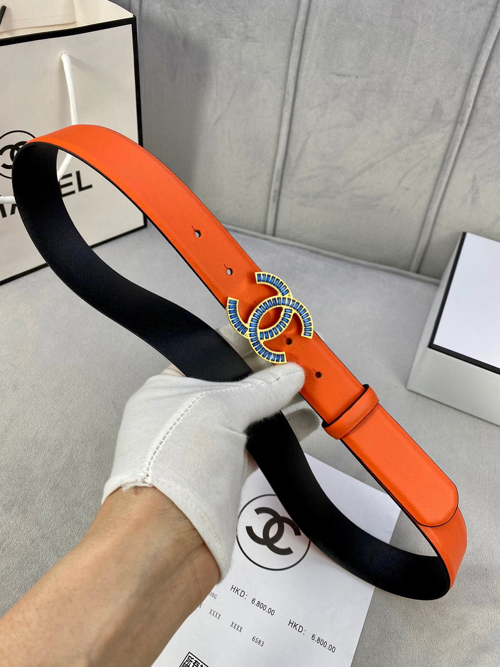 Orange leather belt with blue CC buckle and black inner side