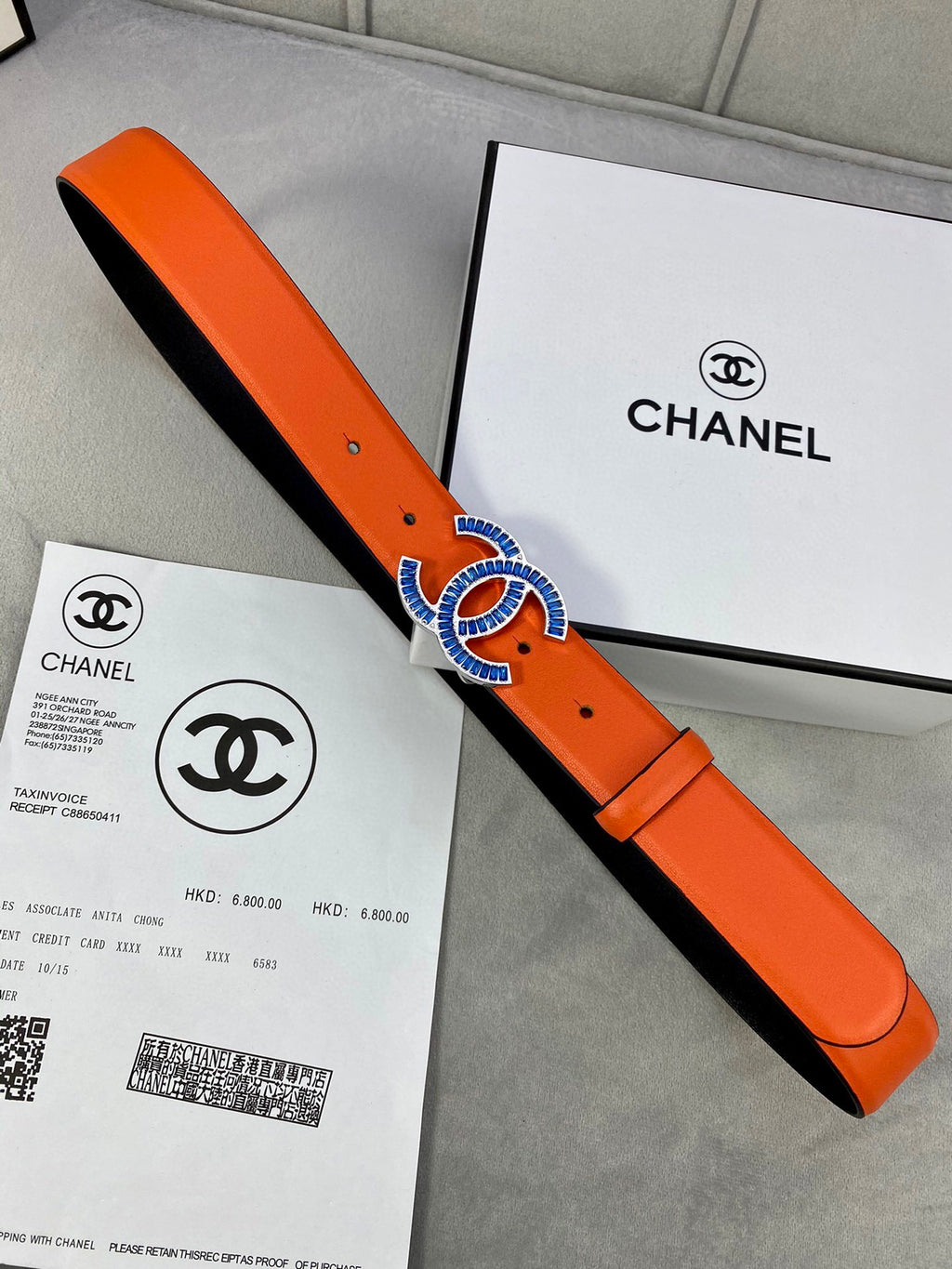 Orange leather belt with blue CC buckle and black lining