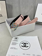 Pink leather belt with blue-and-gold CC buckle, shown folded on a box