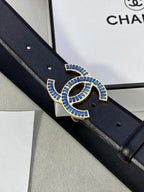 Chanel black leather belt close-up with blue and gold CC logo buckle detail