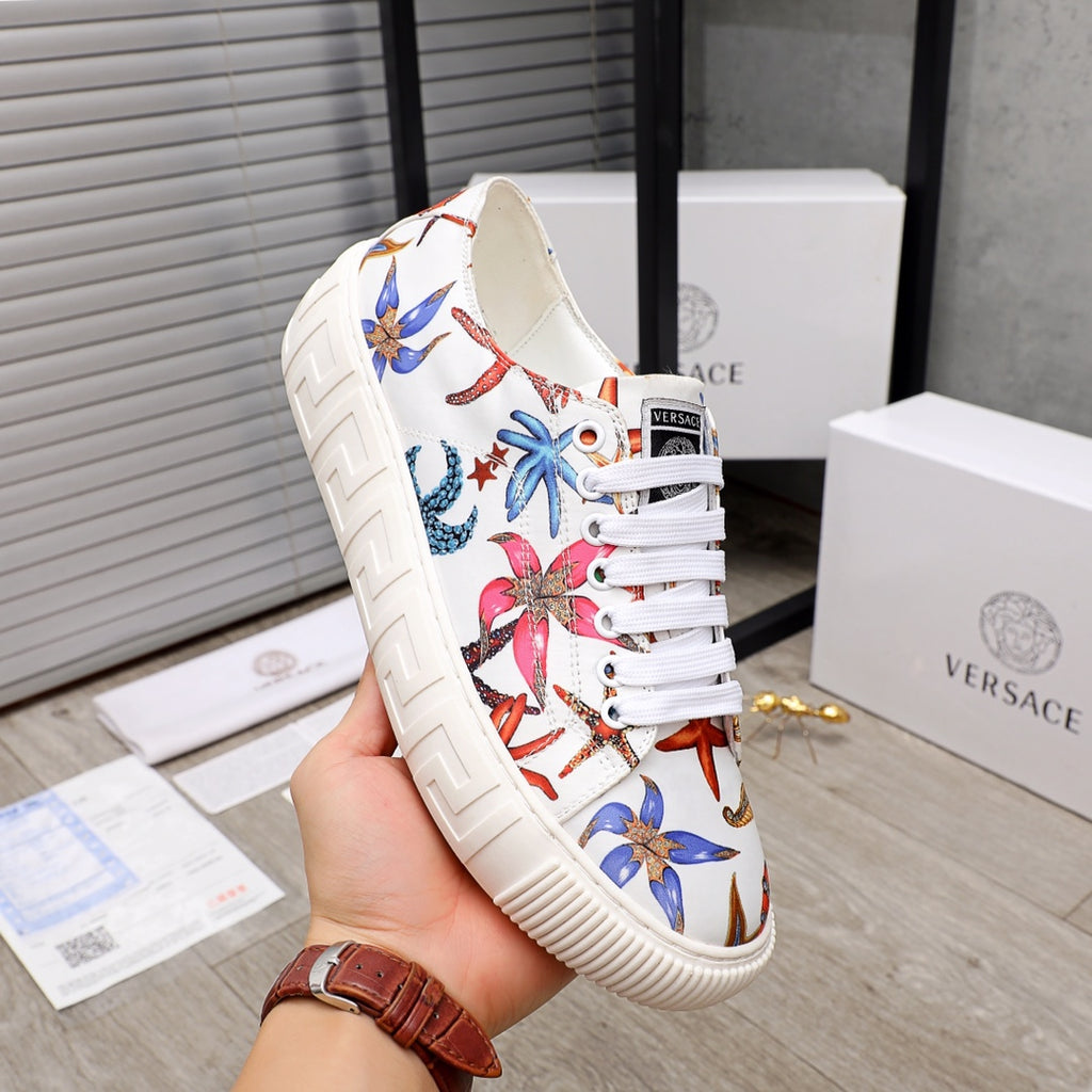 White low-top sneaker with colorful sea-print panels and white laces, chunky ridged sole.