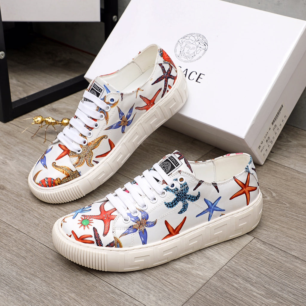 Pair of white low-top sneakers with colorful sea life print, white laces, thick ridged sole.