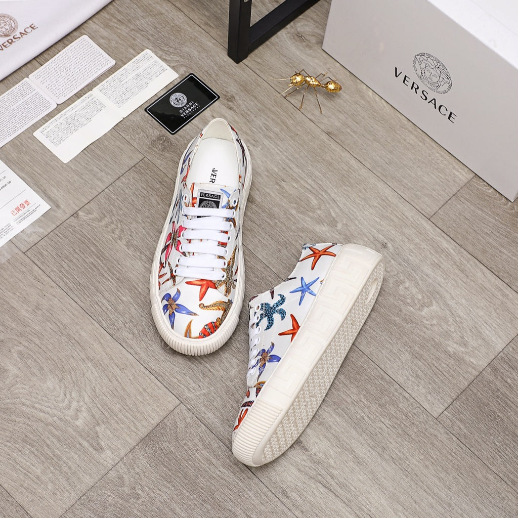 Pair of white low-top sneakers with multicolor sea-life print and white laces, textured sole.
