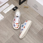 Pair of white low-top sneakers with multicolor sea-life print and white laces, textured sole.