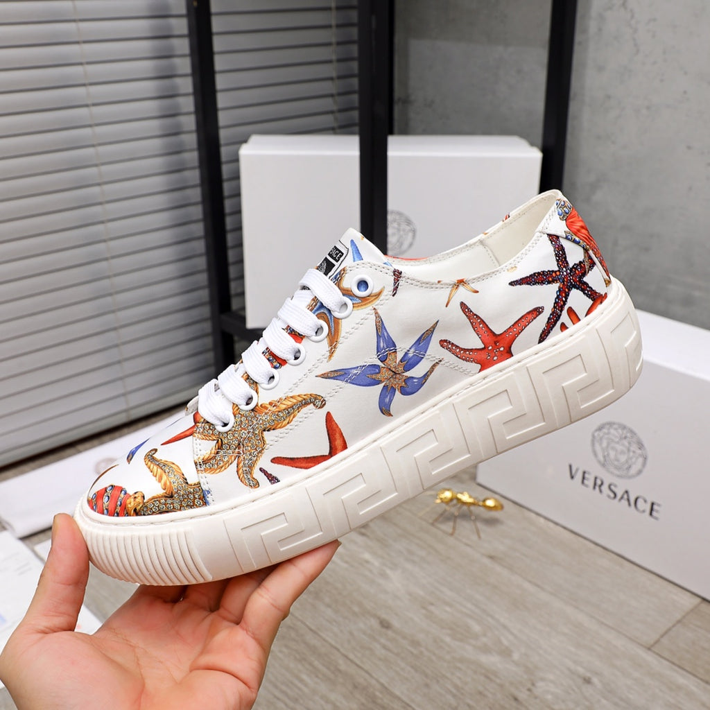 White low-top sneaker with colorful starfish and sea-life print, white laces, chunky sole.