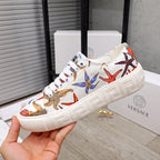 White low-top sneaker with colorful starfish and sea-life print, white laces, chunky sole.