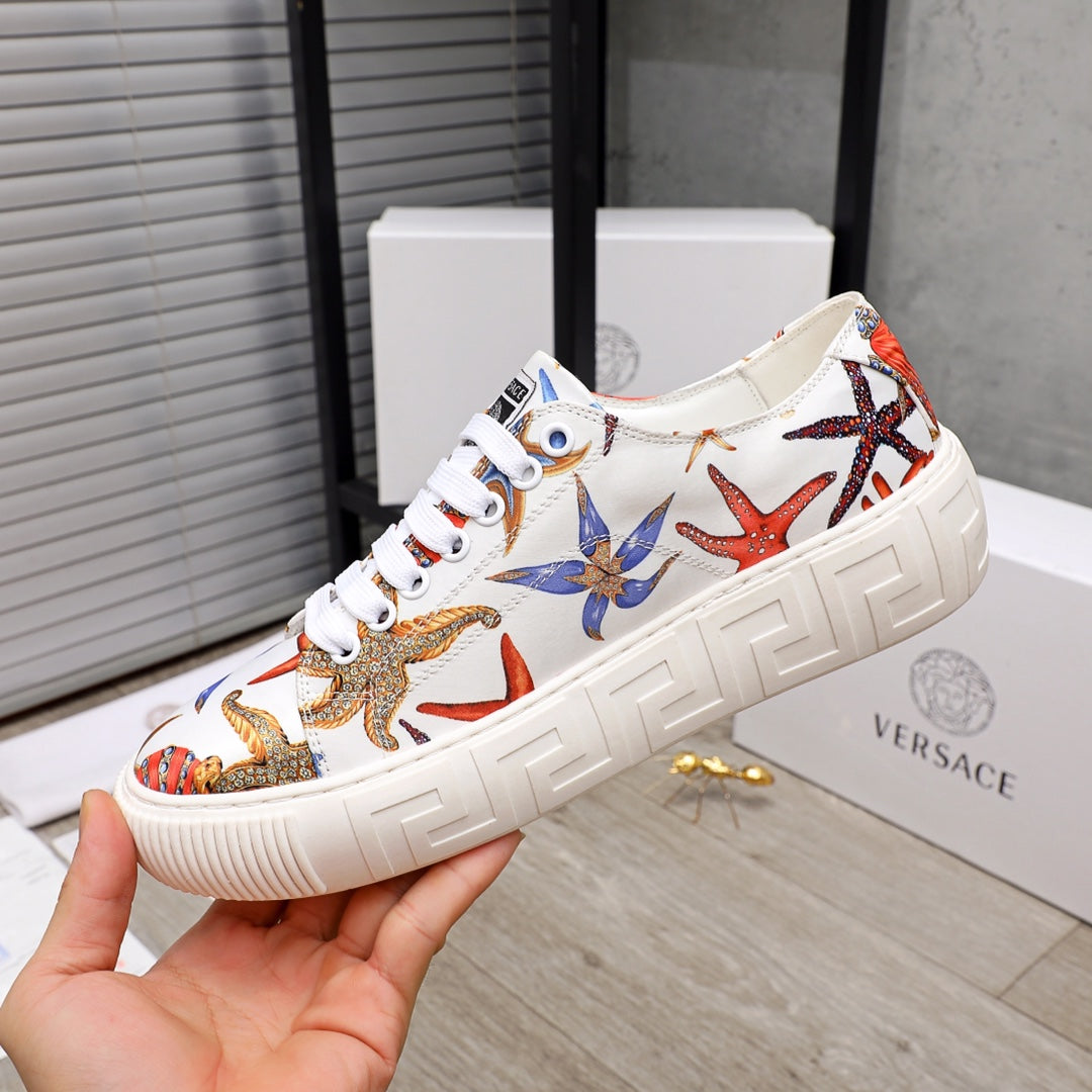 White low-top sneaker with colorful starfish and sea-life print, white laces, chunky sole.