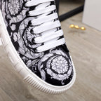 Versace luxury sneakers, close-up of white laces on black-and-white baroque upper