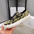 Versace luxury sneaker side view, black-and-yellow baroque pattern, black lace-up, white platform sole