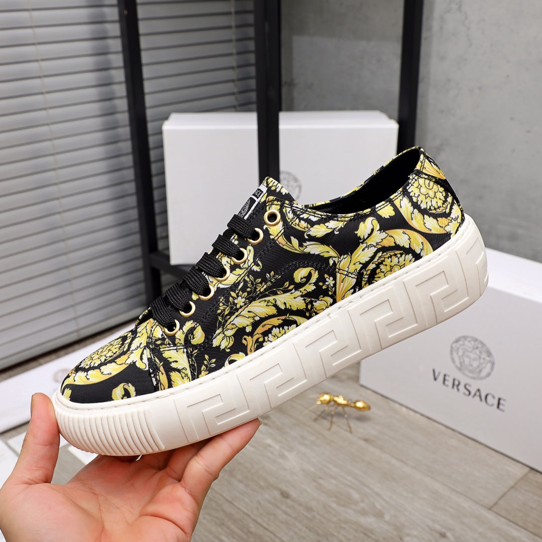 Versace luxury sneaker side view, black-and-yellow baroque pattern, black lace-up, white platform sole