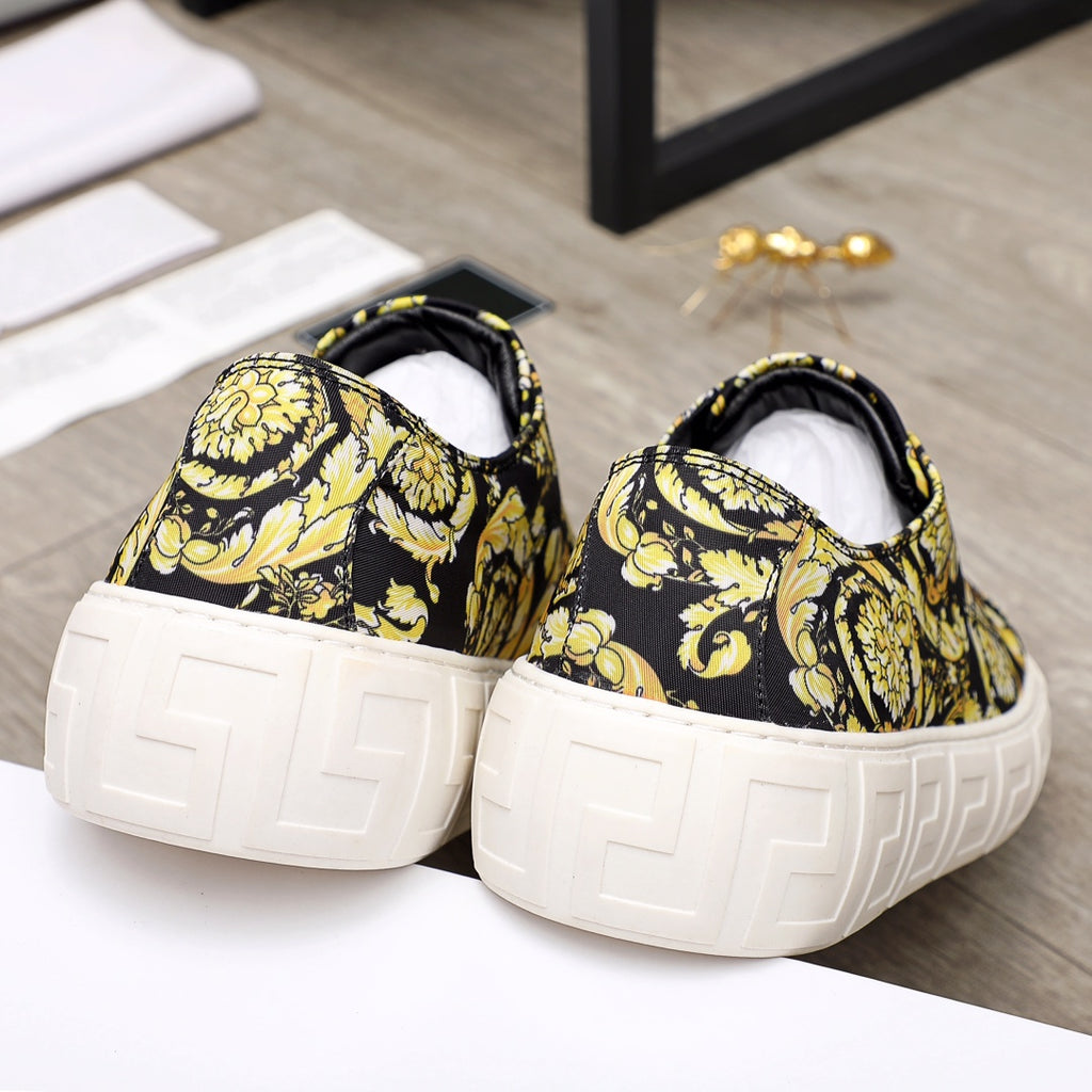Versace luxury sneakers back view, black-and-yellow baroque print with white textured platform soles